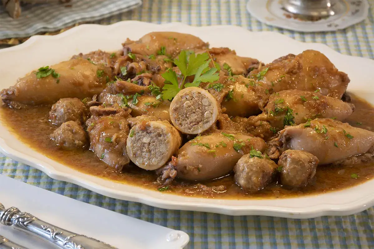 Calamares rellenos tradicionales en una salsa sabrosa, adornados con perejil fresco. Se ven deliciosos y listos para disfrutar.