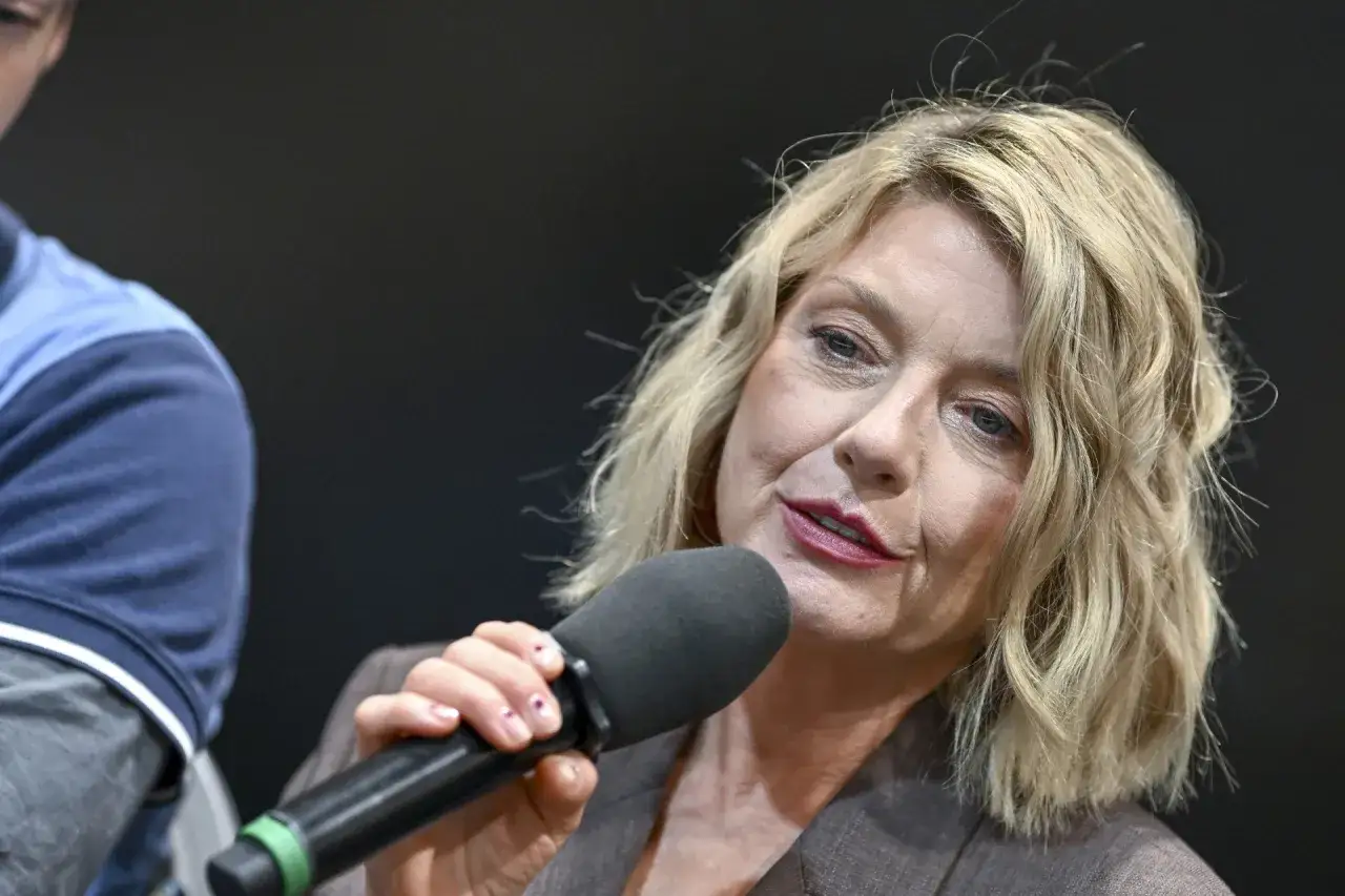 Kobieta z blond włosami, trzymająca mikrofon, mówi do publiczności. Ile lat ma Edyta Olszówka?