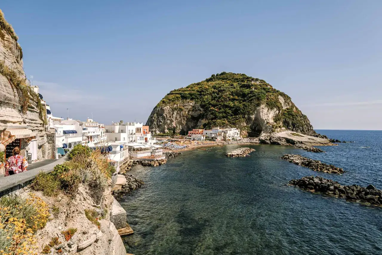 Baia di Sant'Angelo, Ischia. Un angolo di paradiso per il turismo, con case bianche, spiaggia e il monte epomeo sullo sfondo.