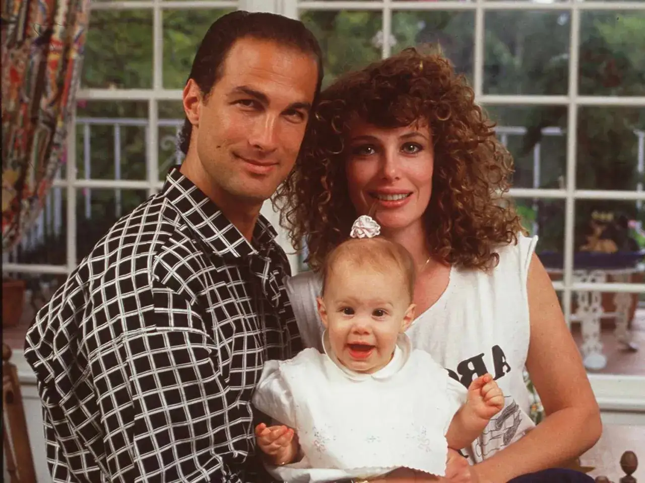 Steven Seagal z żoną i ich małe dzieci. Uśmiechnięta rodzina pozuje do zdjęcia.