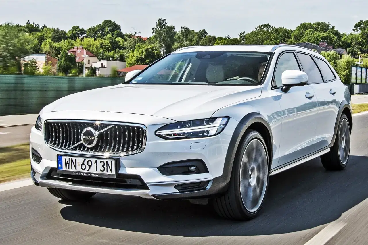 Białe Volvo V90 Cross Country w ruchu. Wiele osób szuka volvo v90 cross country opinie, ten model zachwyca.