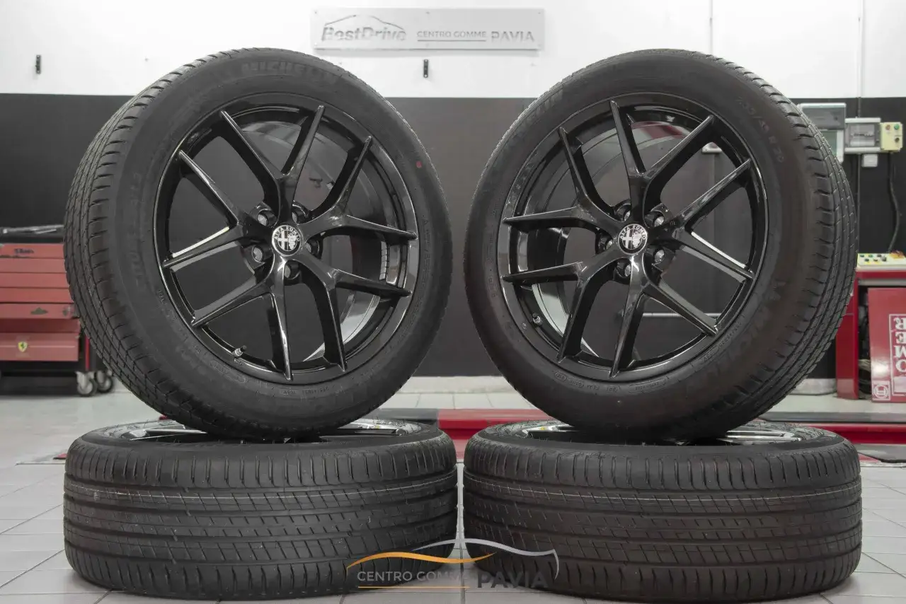 Cerchi in lega neri lucidi con logo Alfa Romeo, perfetti per un'Alfa Romeo Stelvio. Gomme Michelin Latitude Sport 3.