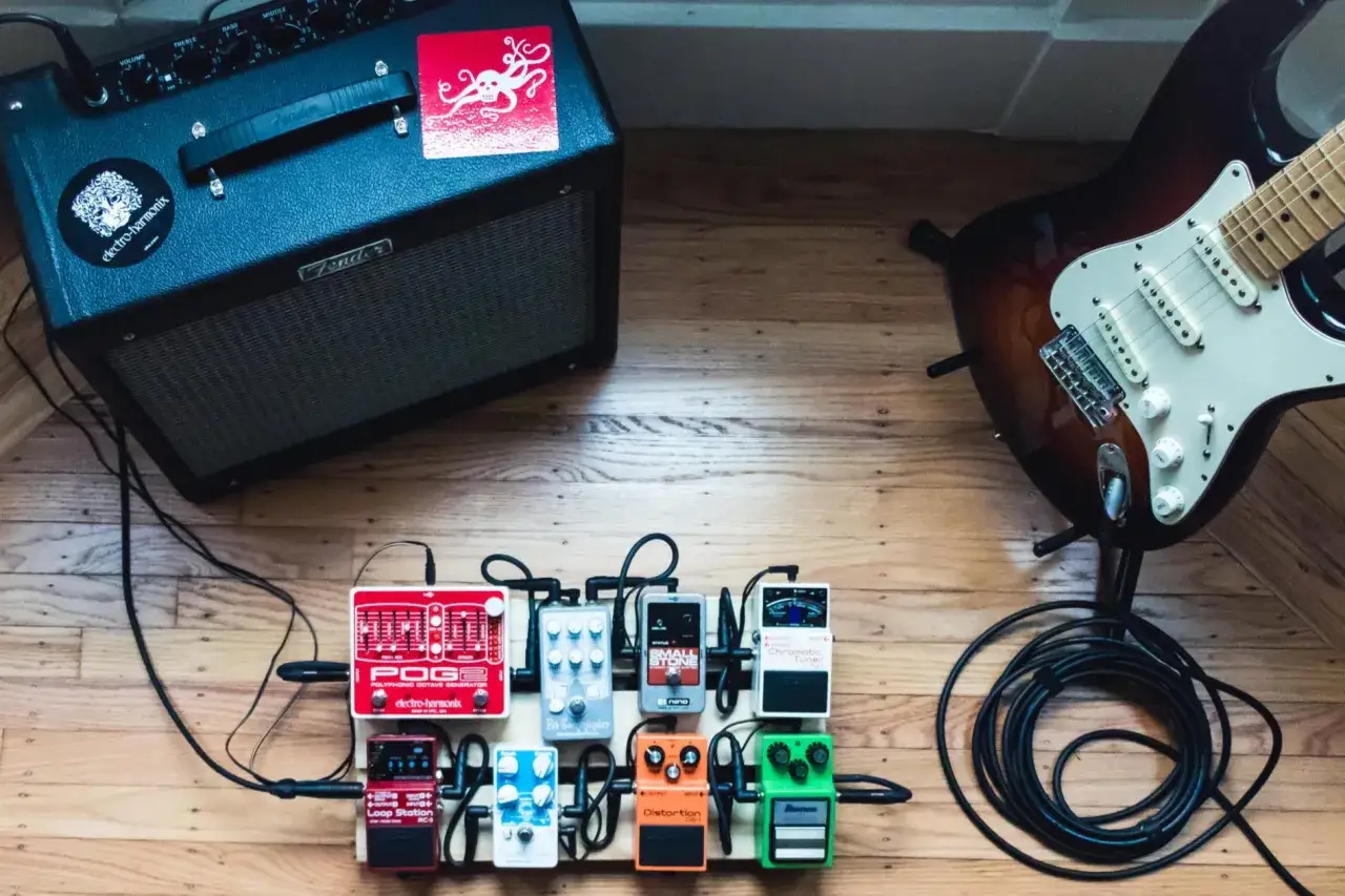 Zestaw do nauki gry na gitarze elektrycznej: wzmacniacz, gitara, pedały efektów i kable.