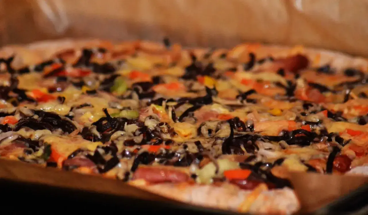 Pyszne, domowe ciasto na pizzę z serem i warzywami. Zastanawiasz się, ile może stać ciasto na pizze? Najlepiej zjeść je od razu!