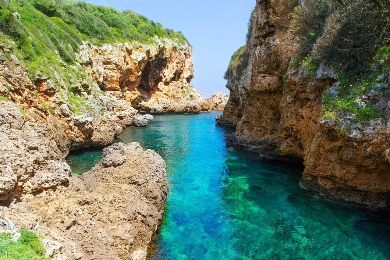 Magnifique paysage minorquin : falaises rocheuses plongeant dans une eau turquoise cristalline, un coin de paradis secret.