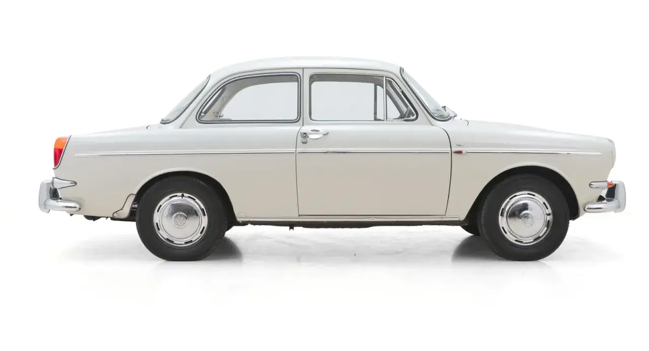 En ljusbeige Audi 50, en klassisk bil med kromdetaljer, står redo för en tur.