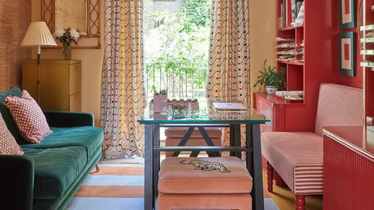 Ein gemütliches Arbeitszimmer mit einem grünen Sofa, einem Schreibtisch und Vorhängen mit einem verspielten **polka dot muster**.