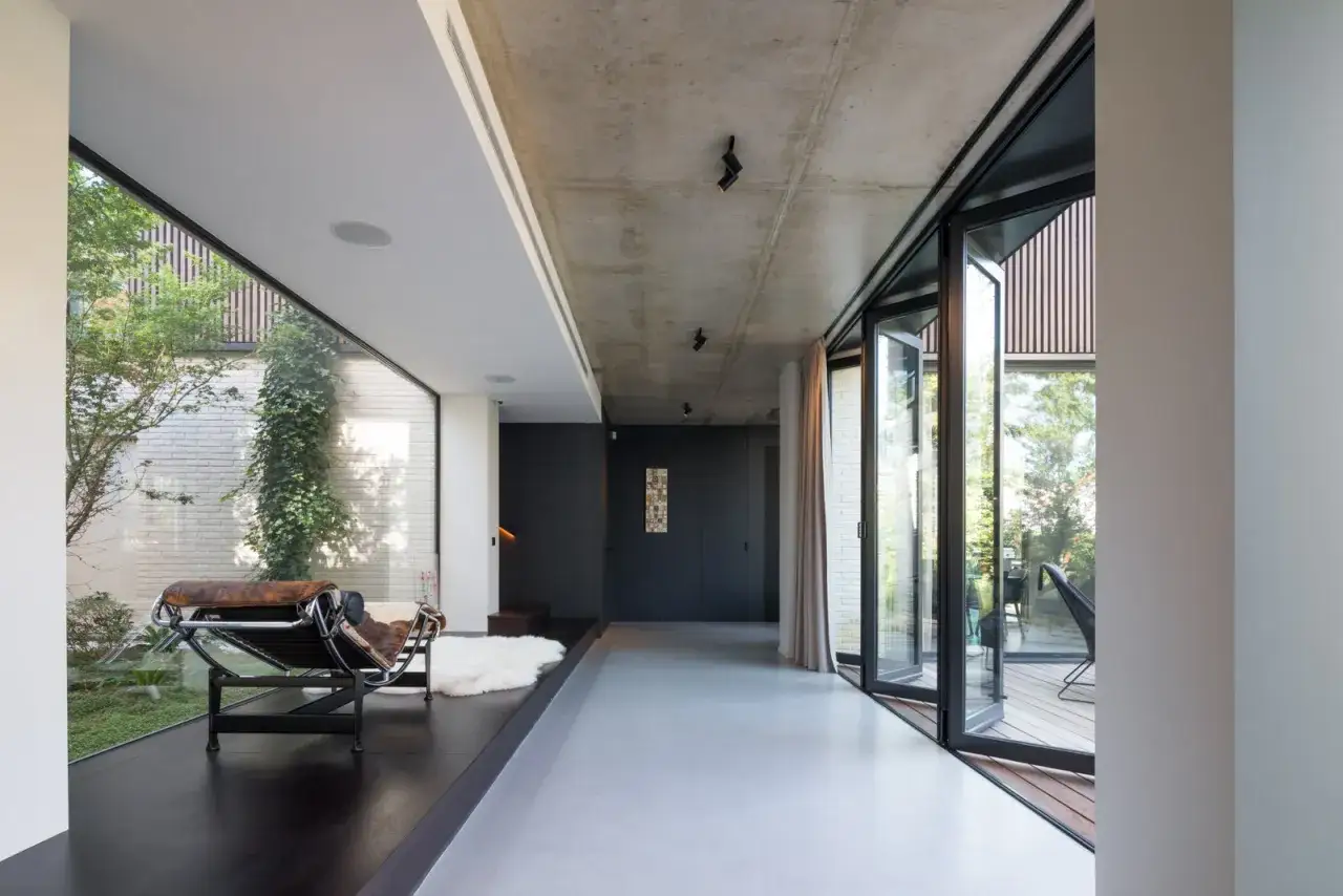 Un fauteuil design face à une baie vitrée, un aperçu du travail d'un photographe architecture.