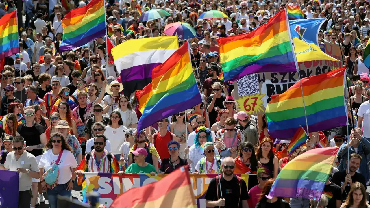 Tęczowe flagi na marszu w Polsce. Ludzie wyrażają wsparcie dla społeczności LGBTQ+, walcząc z homofobią.
