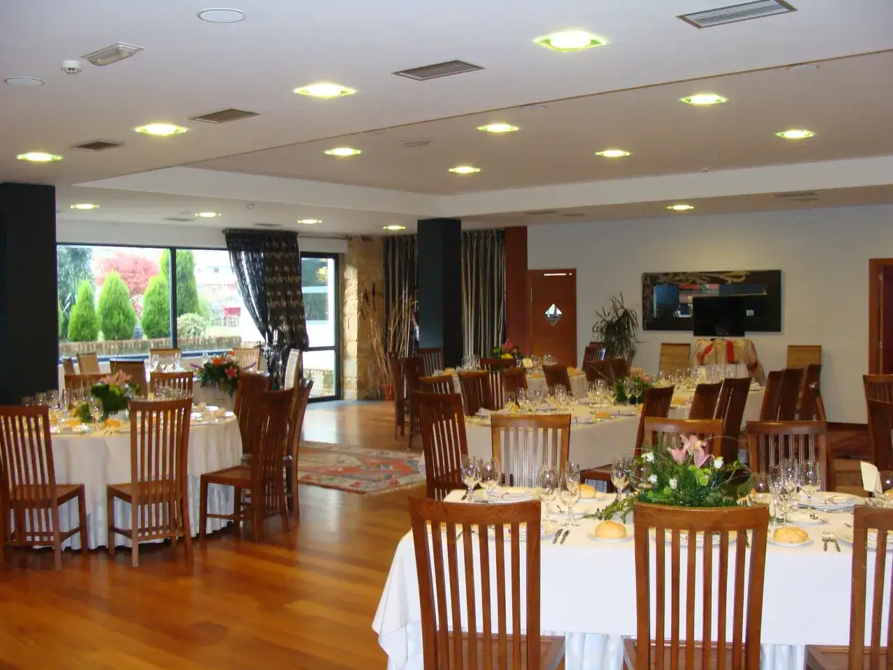 Salón de eventos con mesas puestas, ideal para saber donde comer en Lierganes.