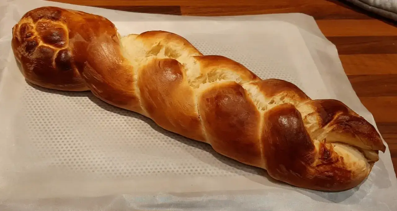 Une belle brioche maison rapide, tress&eacute;e et dor&eacute;e, pr&ecirc;te &agrave; &ecirc;tre d&eacute;gust&eacute;e.
