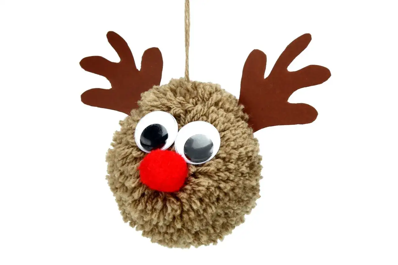 Adorable renne fait main pour fabriquer P&egrave;re No&euml;l en pompon de laine. Ses grands yeux brillants et son nez rouge le rendent irr&eacute;sistible.