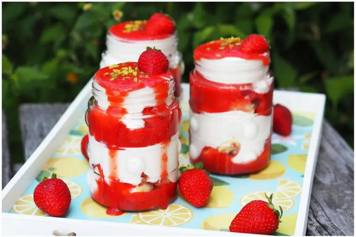 Erdbeer Tiramisu im Glas, geschichtet mit cremiger Mascarpone und frischen Erdbeeren, garniert mit Pistazien.