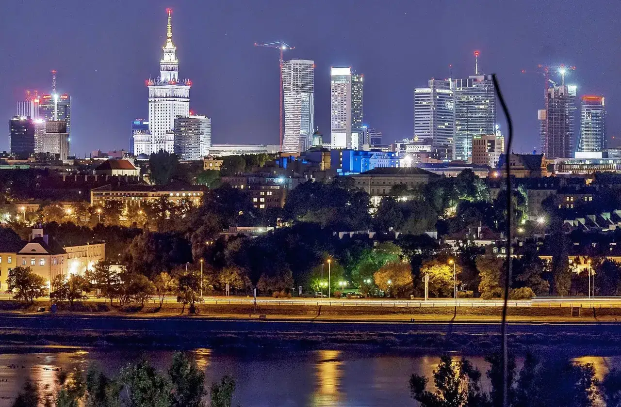 Warszawski krajobraz nocą, z Pałacem Kultury i Nauki, najwyższym budynkiem w Polsce, w centrum.