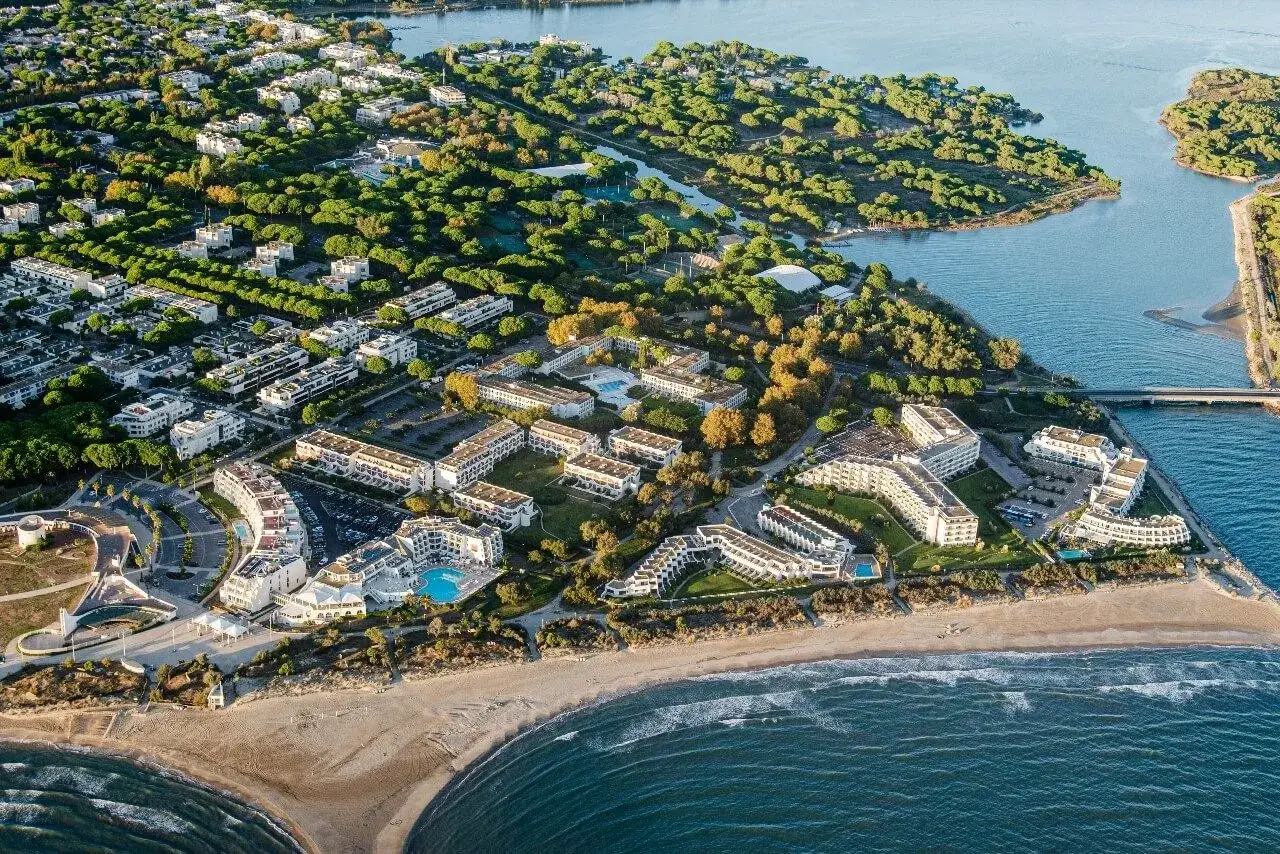 Luftaufnahme eines Resorts am montpellier strand mit wei&szlig;en Geb&auml;uden, Pools und viel Gr&uuml;n.