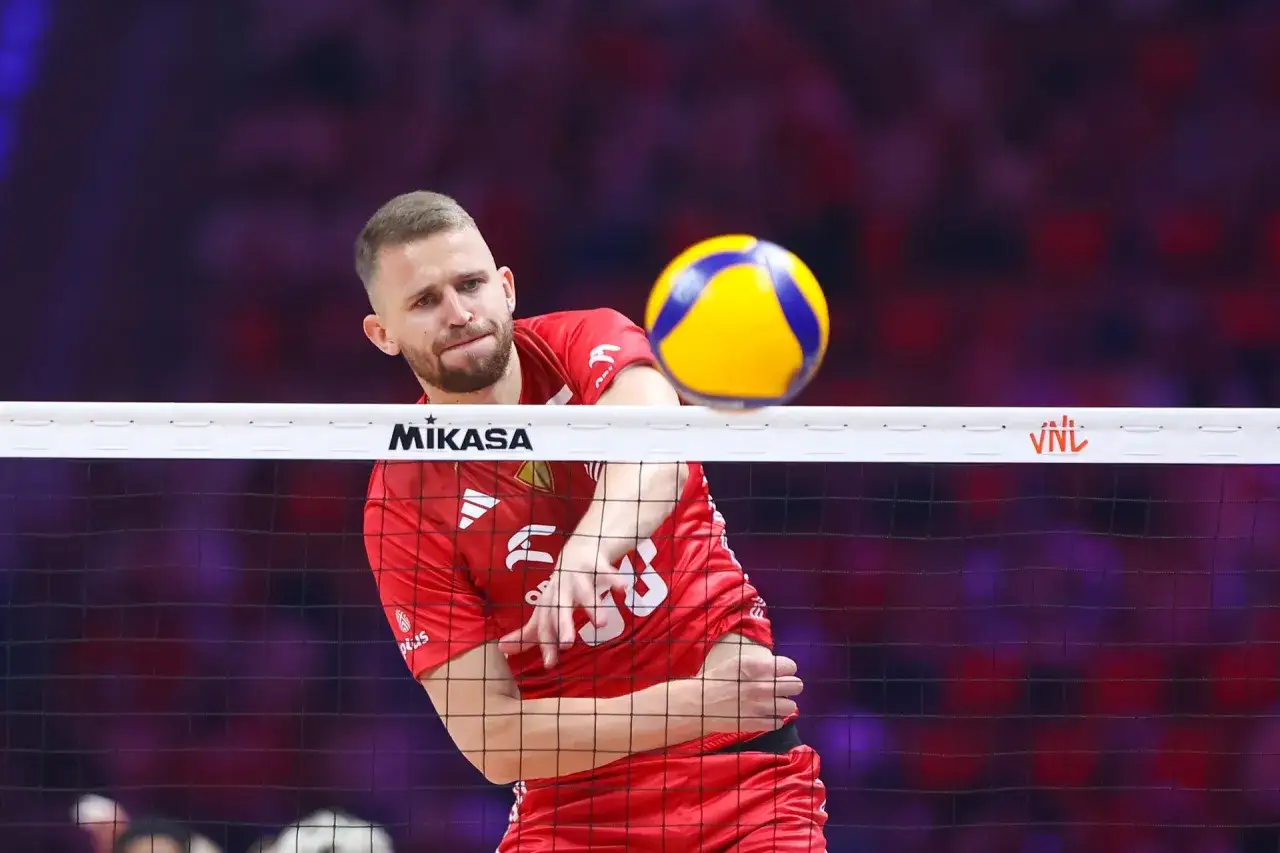 Bartosz Bołądź w akcji, zagrywa piłkę do przodu, skupiony na grze.