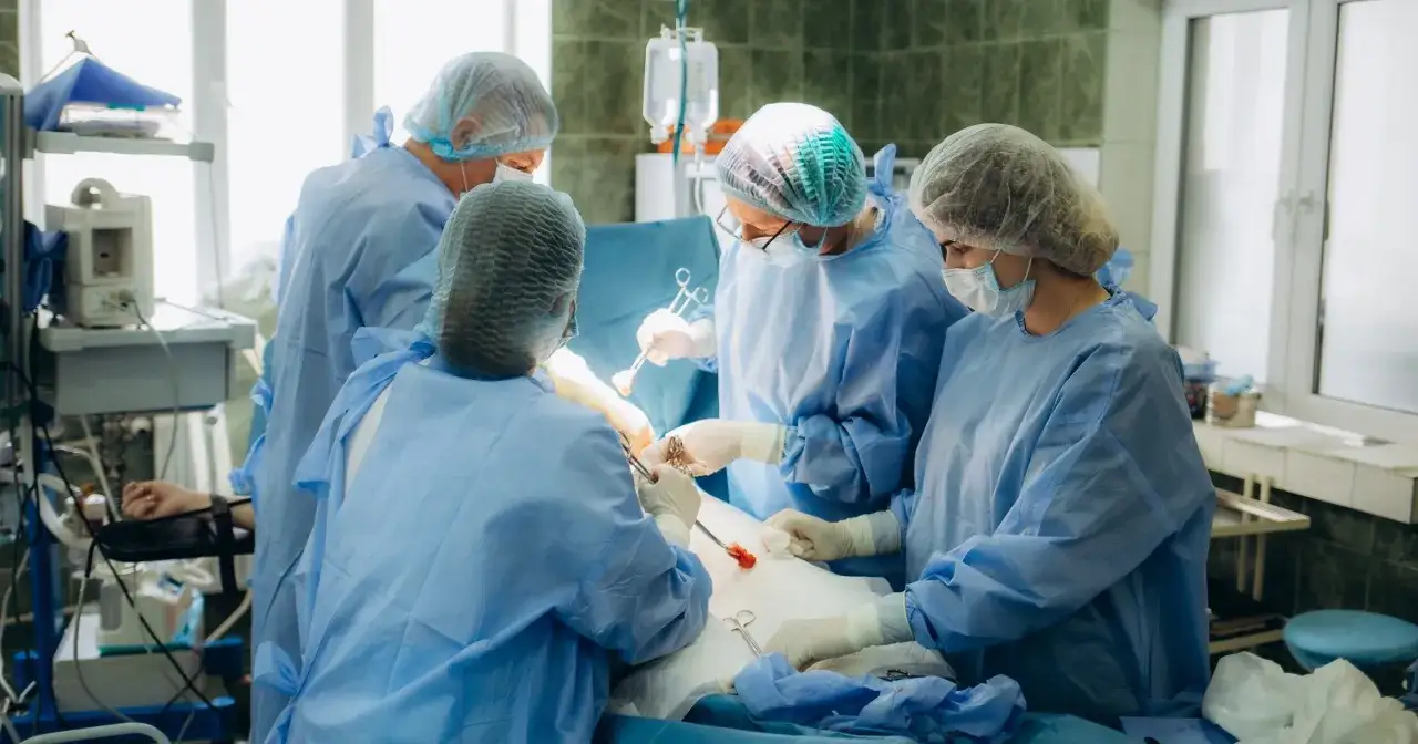 Chirurdzy podczas operacji, która może dotyczyć dylematów etycznych związanych z transplantacją organów a religią.