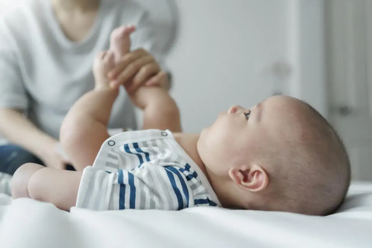 Rodzic przygotowujący się do pobrania moczu od niemowlaka chłopca
