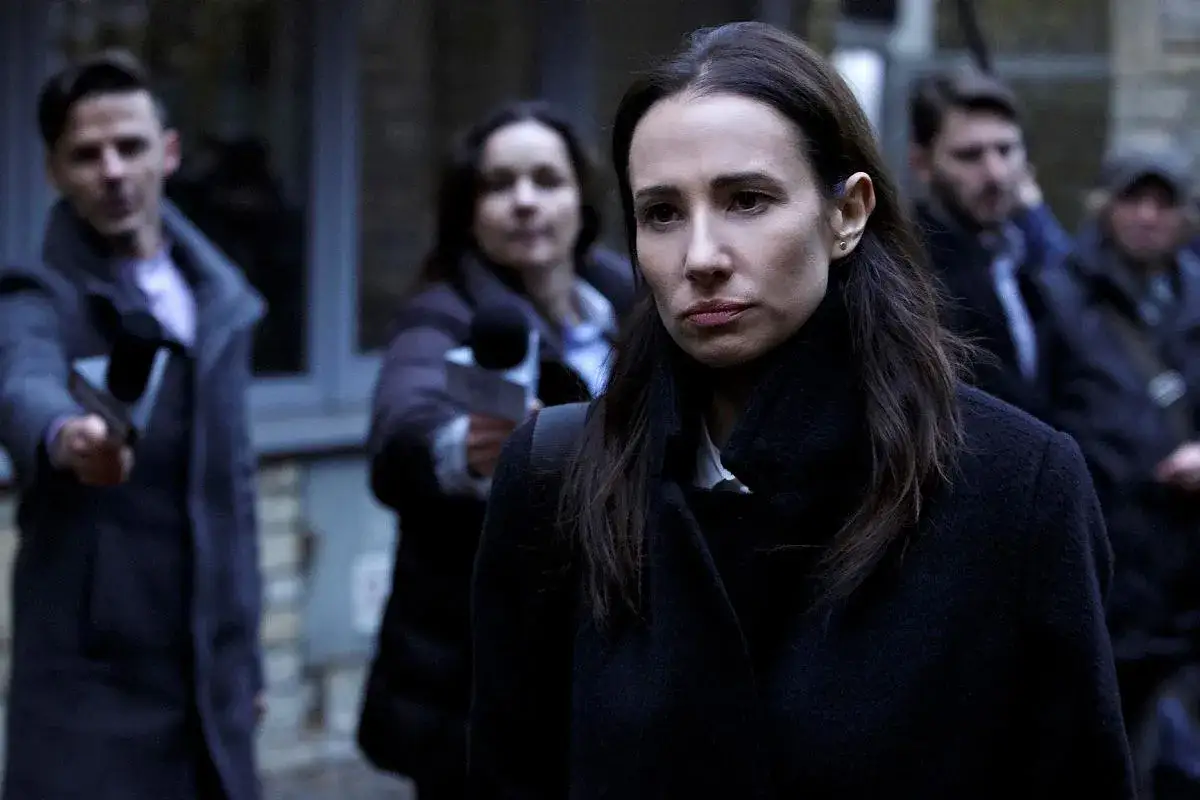 Aleksandra Popławska w mrocznej scenie z filmów i seriali. W tle mężczyzna z nożem, sugerujący napięcie.