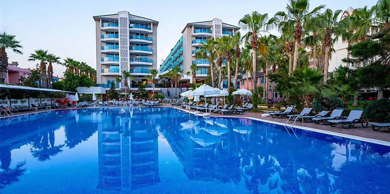 Basen hotelowy z leżakami i palmami, idealne miejsce na relaks przy Concordia Celes Beach.