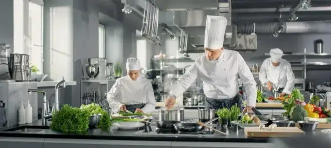 Team von K&ouml;chen und Servicekr&auml;ften in einer professionellen Gro&szlig;k&uuml;che