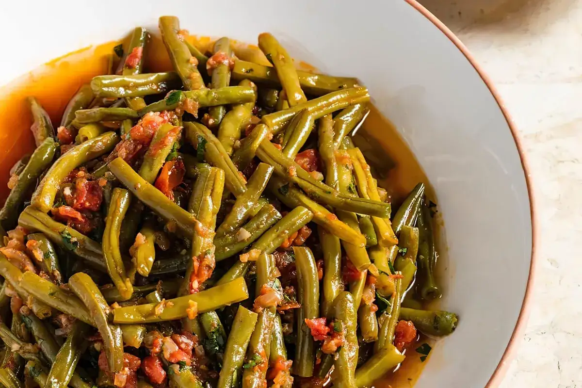 Haricots verts &agrave; l'italienne, tendres et savoureux, mijot&eacute;s dans une sauce tomate parfum&eacute;e. Un plat simple et d&eacute;licieux.