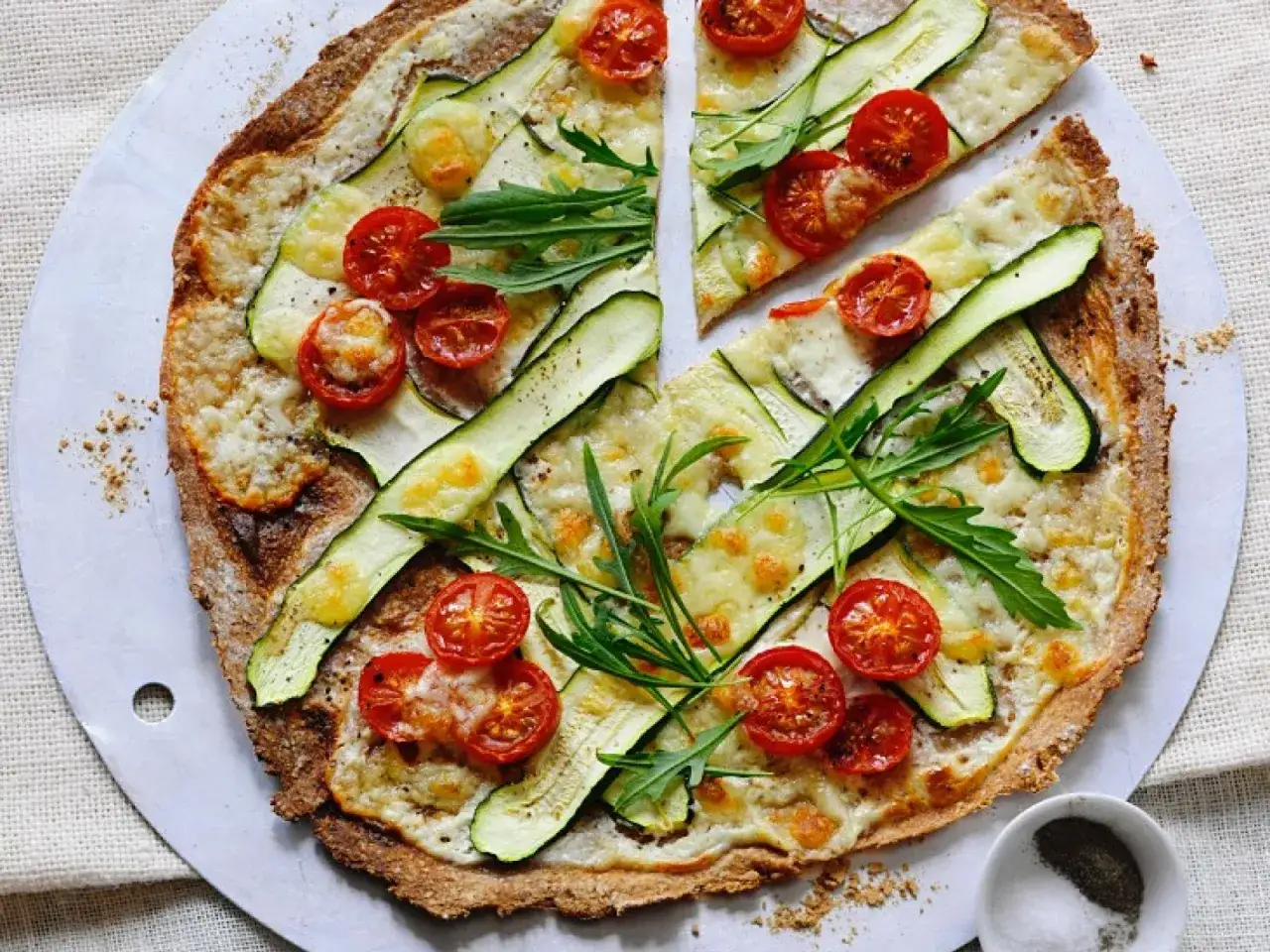 Flammkuchen vegetarisch mit Zucchini, Kirschtomaten und Rucola. Ein Genuss f&uuml;r alle Sinne!
