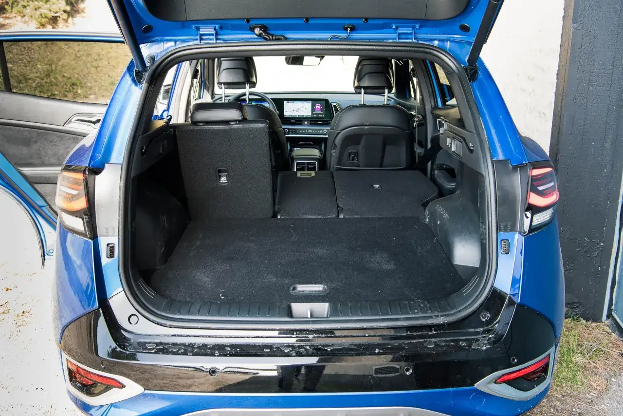 Bagageutrymmet i en blå Kia Sportage, perfekt för en familjeresa. En begagnad Kia Sportage test visar hur rymlig den är.