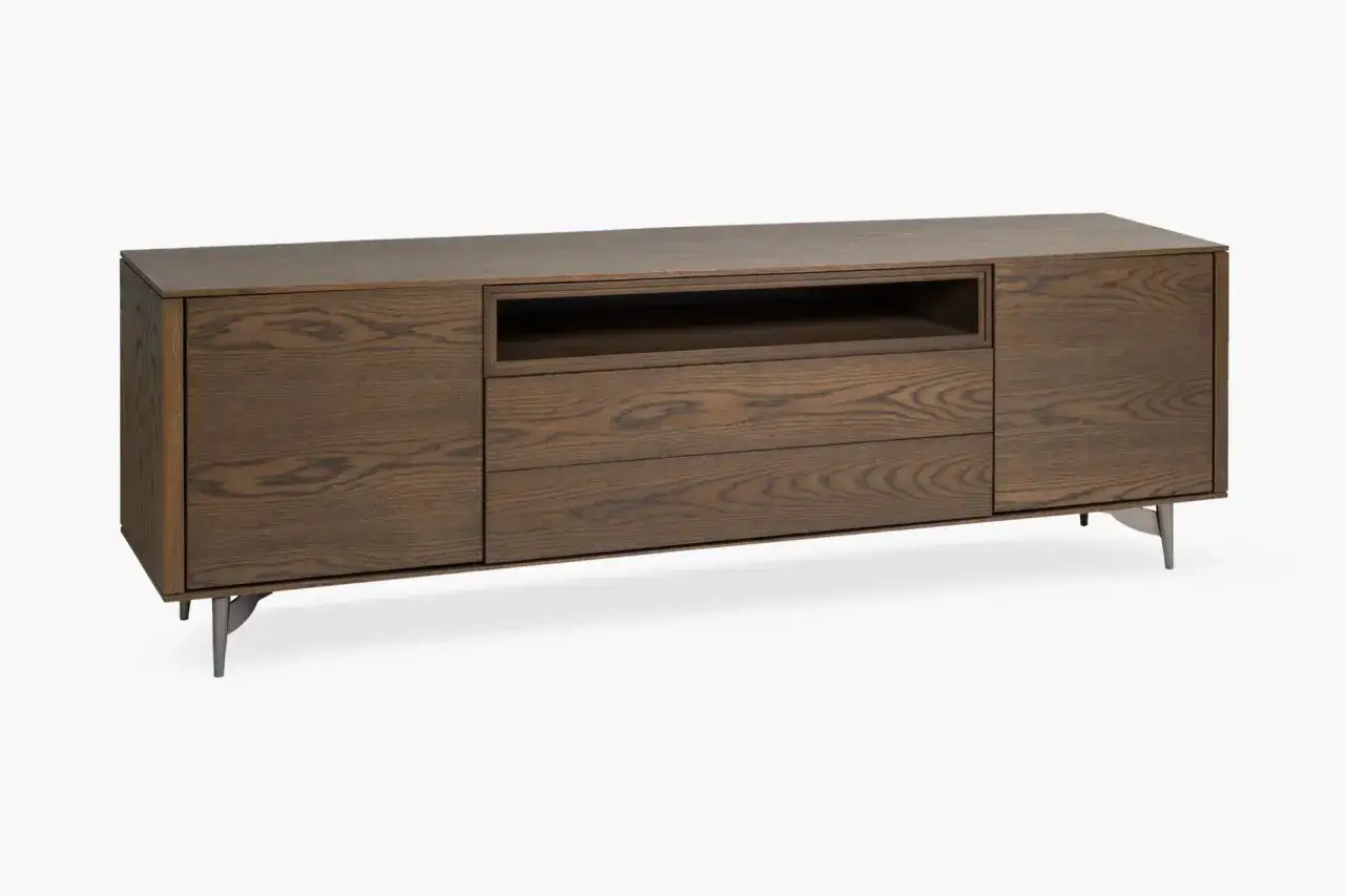 Aparador moderno de madera de roble oscuro, con un hueco central y tres cajones. Sus patas metálicas le dan un toque contemporáneo.
