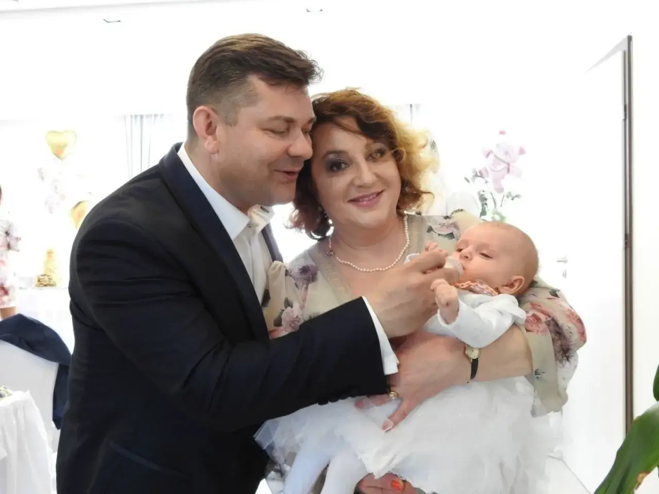 Szczęśliwi rodzice karmią butelką swoje maleństwo. Czy to pierwsze dziecko Zenka?