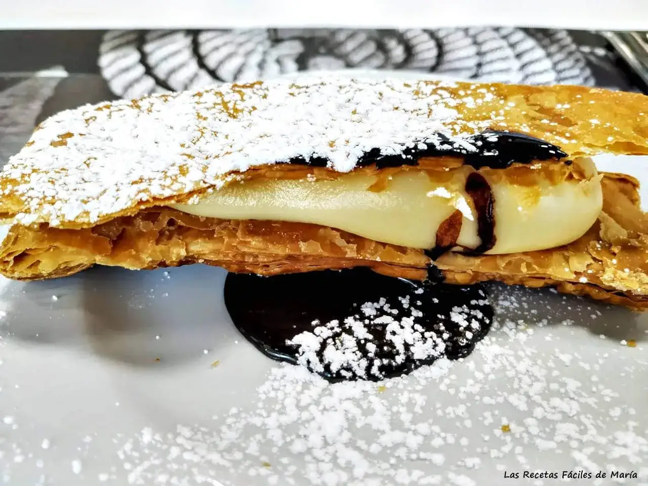 Delicioso milhojas de chocolate con crema y espolvoreado de az&uacute;car glas.