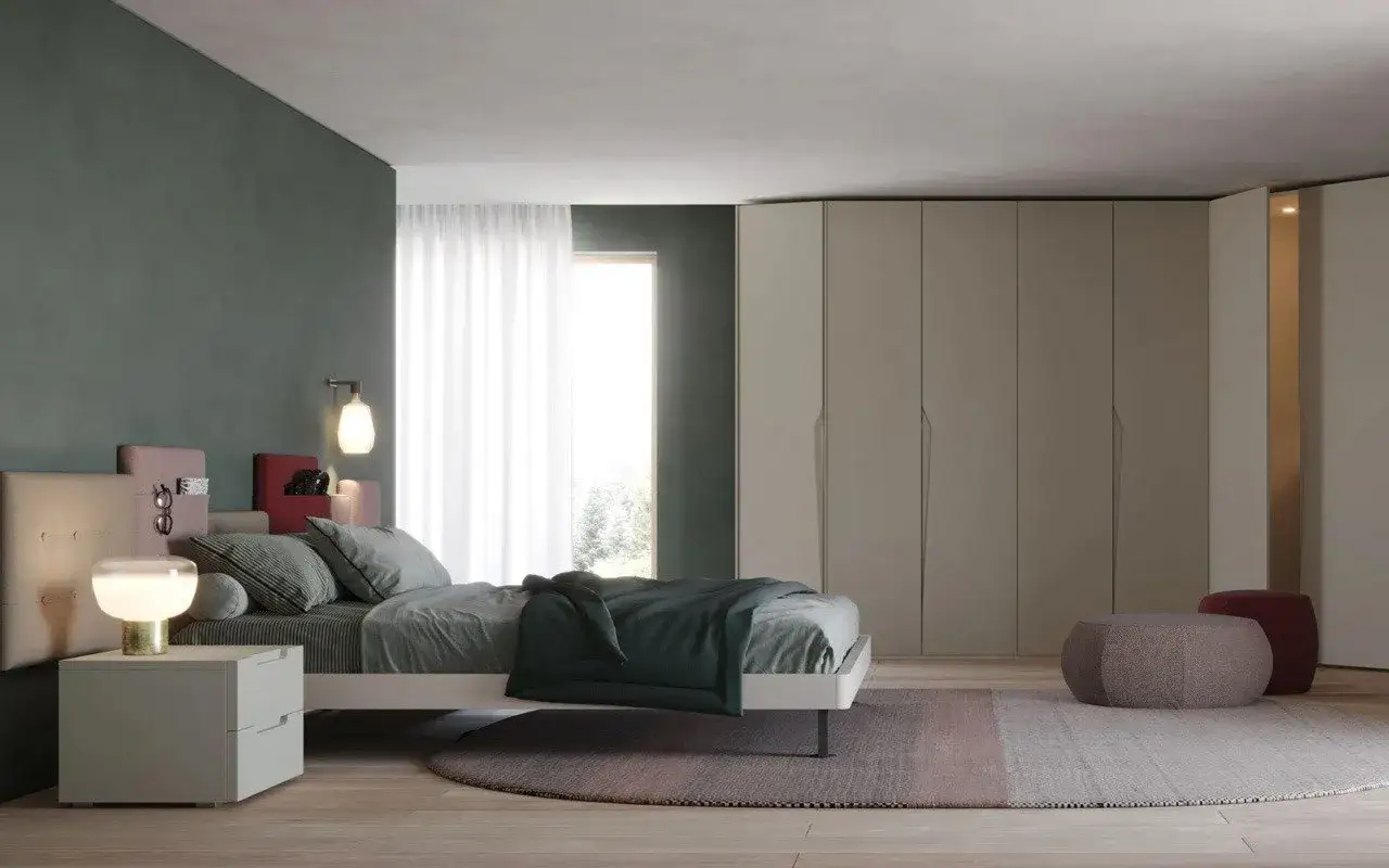 Camera da letto con pareti verdi e armadi beige. Cuscini e coperta verde scuro creano un'atmosfera rilassante, mostrando i **colori che stanno bene con il verde**.