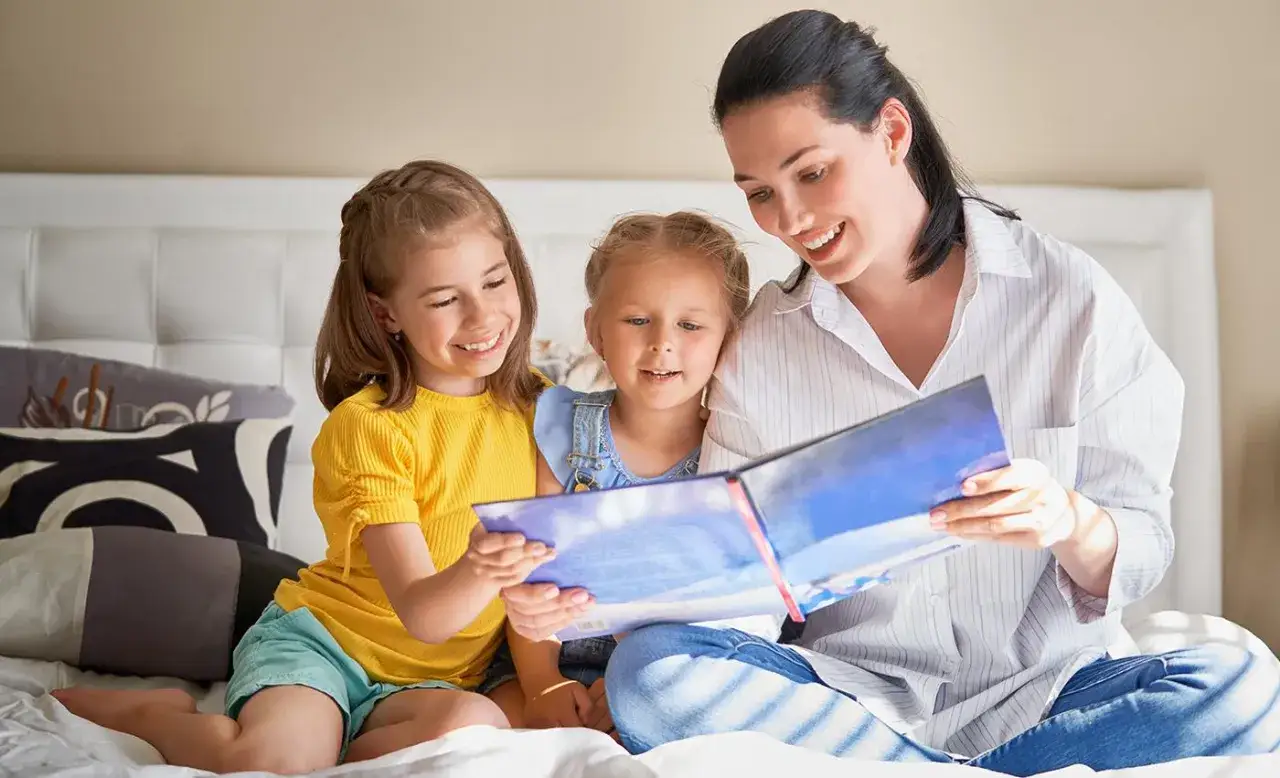 Mama czyta dzieciom bajkę, pokazując, jak zachęcić dziecko do czytania. Radość i wspólne chwile przy książce.