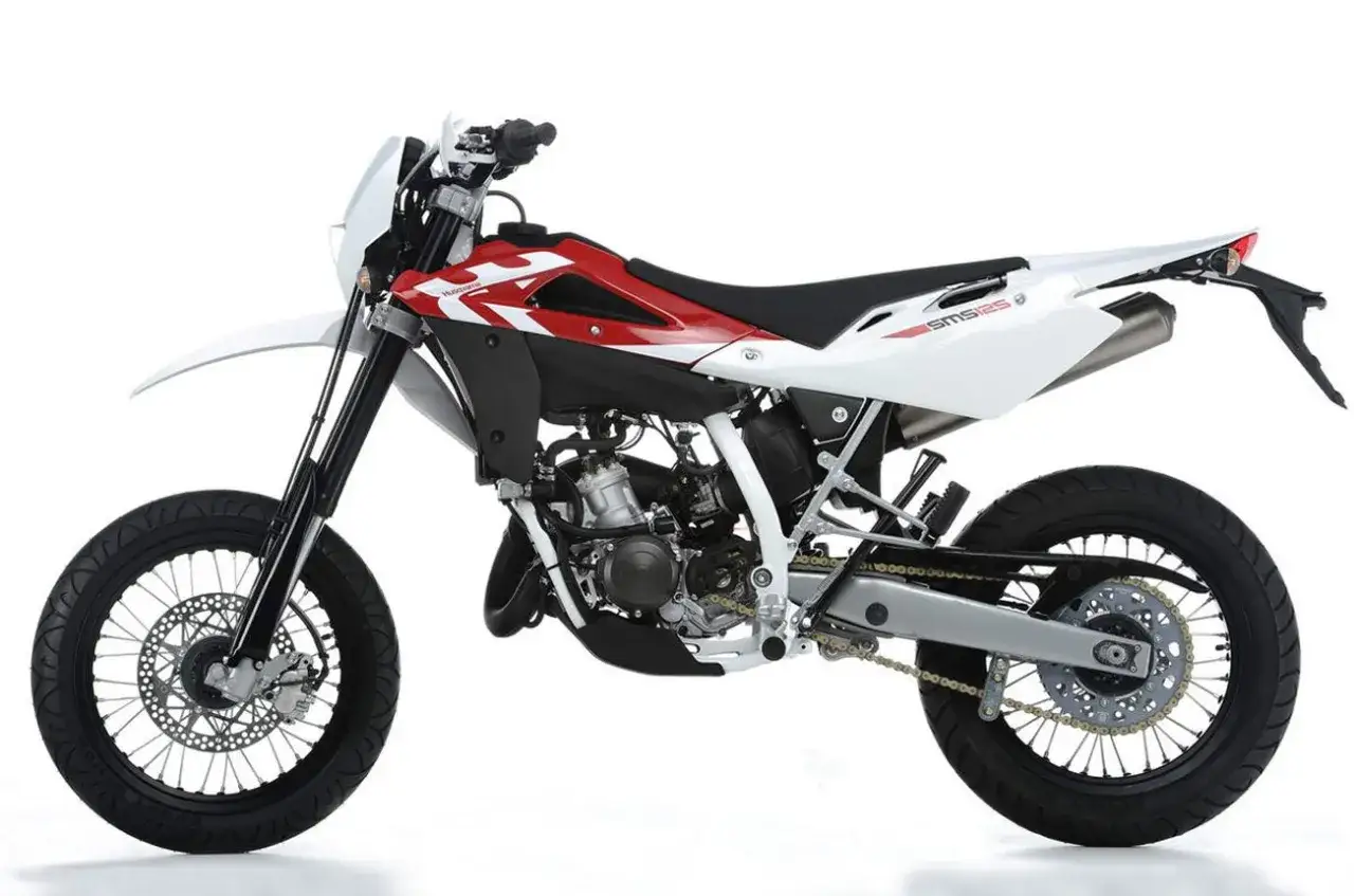 Husqvarna SM 125 dane techniczne: sportowy motocykl supermoto w białej i czerwonej kolorystyce, z widocznym silnikiem i kołami.