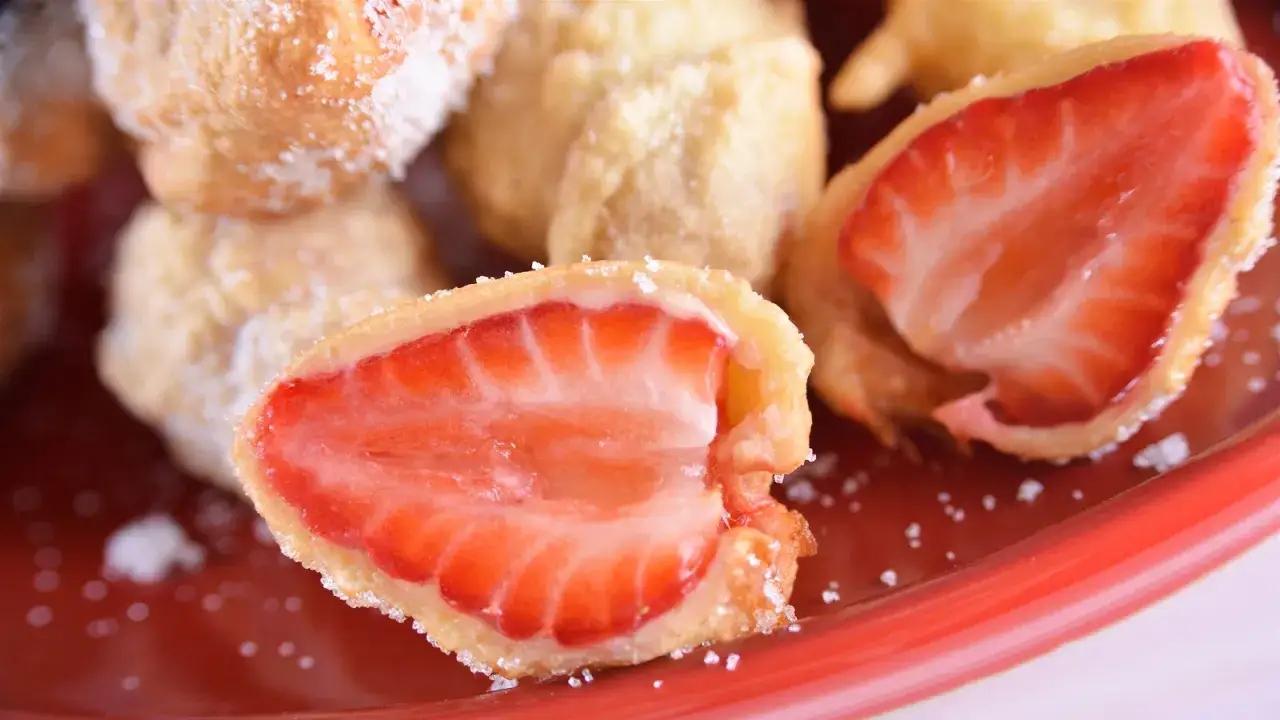 Dulces besos de fresa cubiertos de masa crujiente y azúcar, listos para ser devorados.