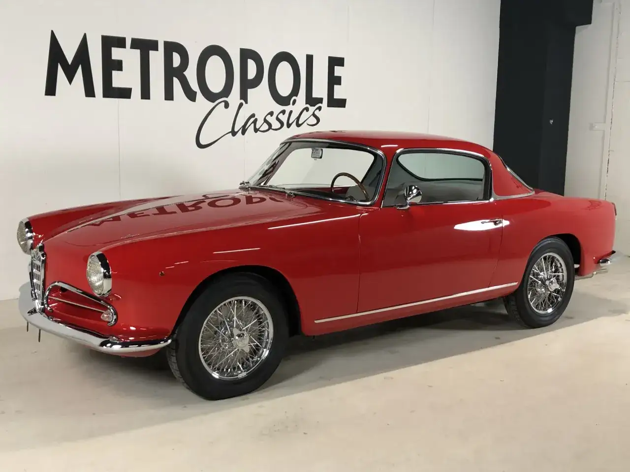 Röd Alfa Romeo Giulietta Sprint Speciale, en av många klassiska Alfa Romeo modeller, står redo för en tur.