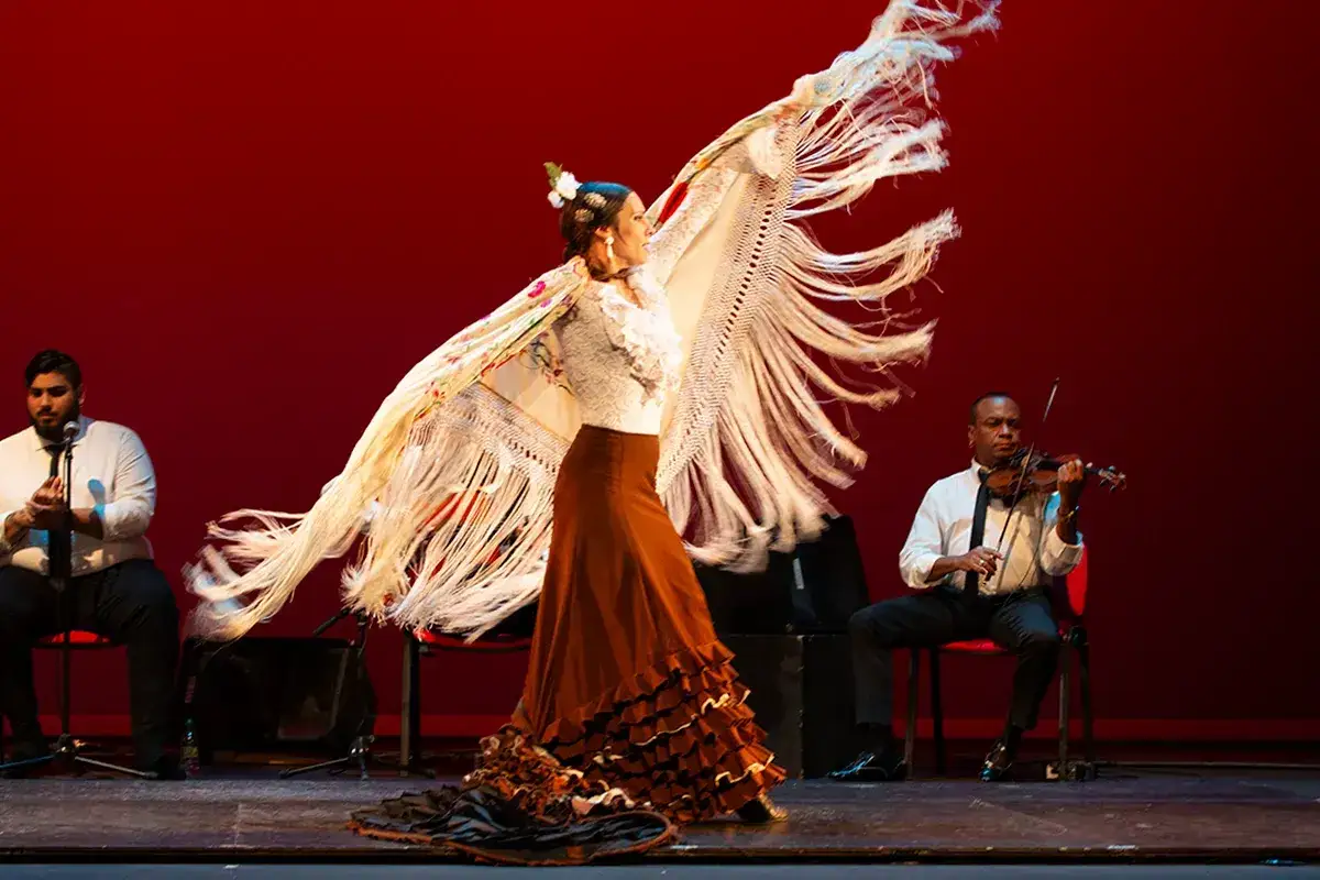 Bailarina flamenca con mantón de Manila de origen asiático, acompañada por violinista y cantante.