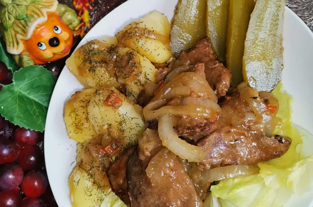 Miękka wątróbka wieprzowa duszona z cebulką, podana z ziemniakami i ogórkami kiszonymi. Sekret tkwi w odpowiednim przygotowaniu.
