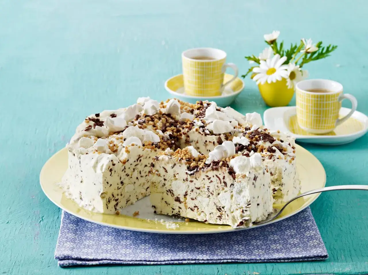 Eissplittertorte Rezept: Eine köstliche Eistorte mit Schokoladenstückchen und Baiser-Topping, serviert mit Kaffee.