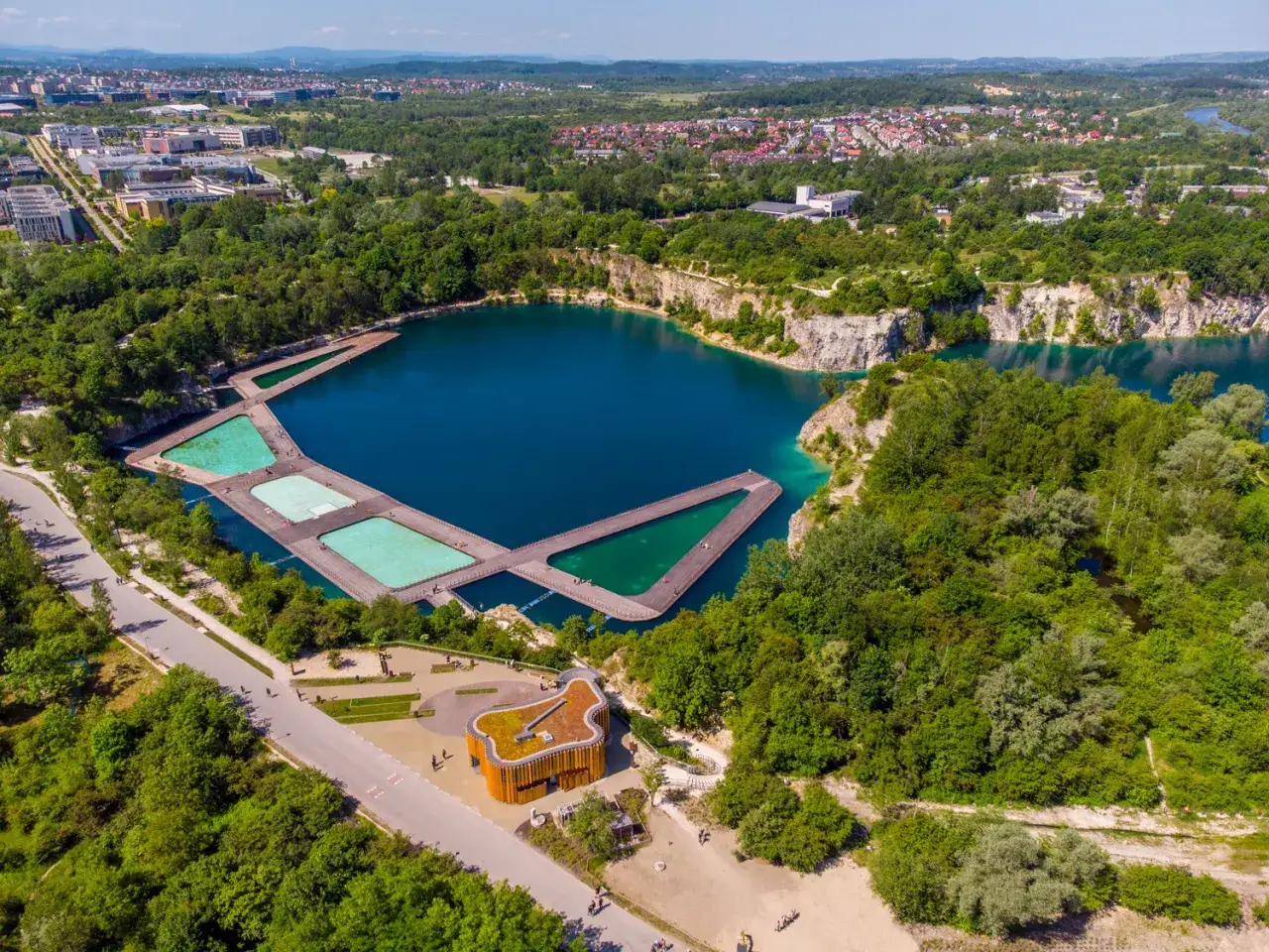 Kraków Jezioro Zakrzówek: turkusowa woda w kamieniołomie, drewniane pomosty i zielone otoczenie tworzą malowniczy krajobraz.