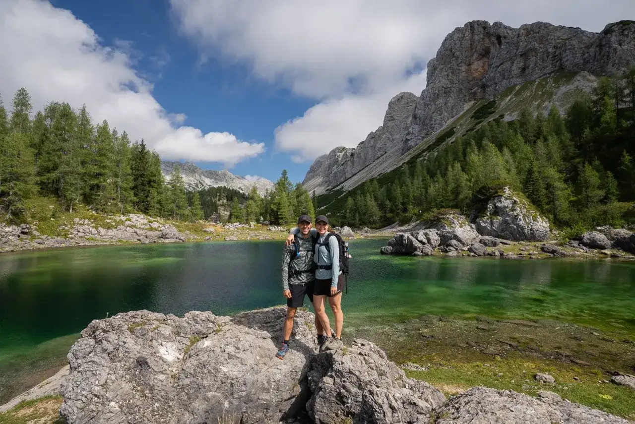 Glückliches Paar beim Wandern in Slowenien, umgeben von smaragdgrünen Seen und majestätischen Bergen.