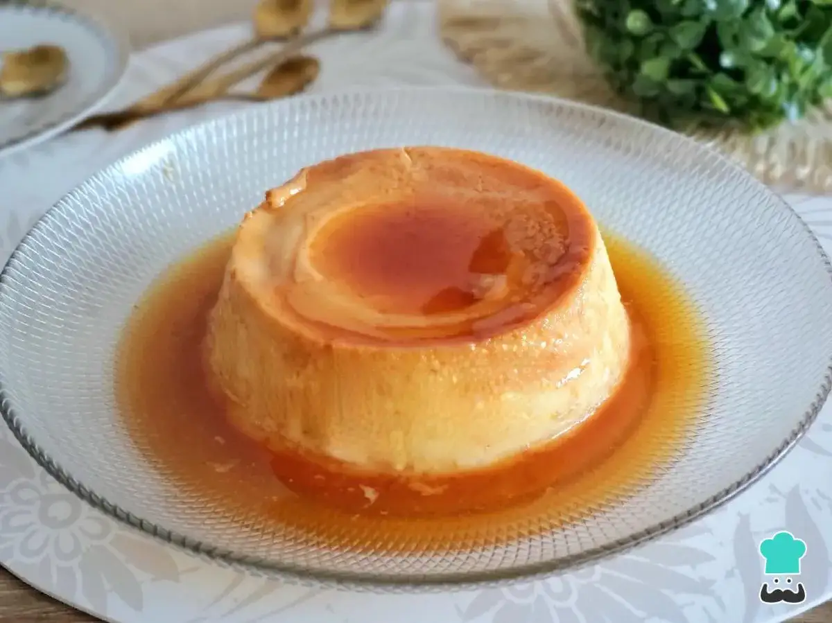 Delicioso flan casero bañado en caramelo líquido, servido en un plato de cristal.