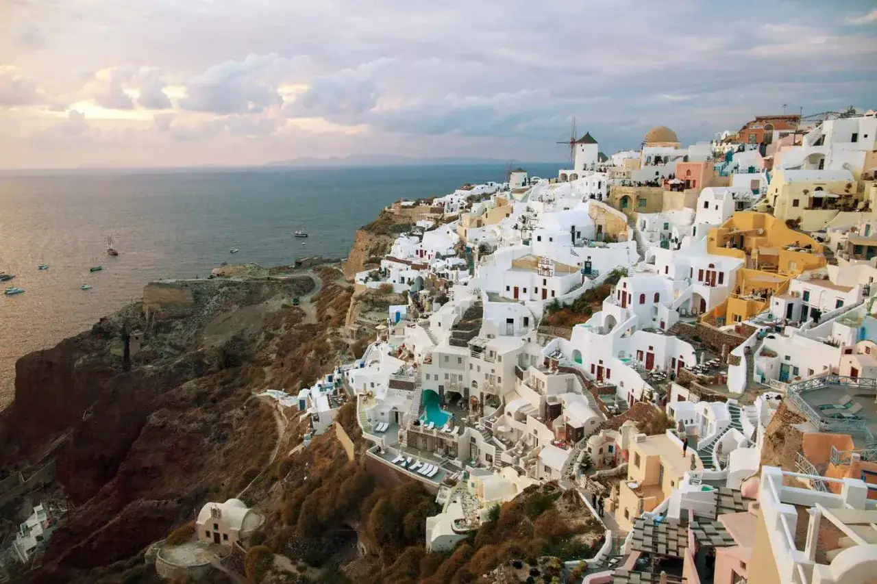 Widok na białe domy Santorini, jedne z najpiękniejszych wysp greckich, schodzące ku morzu.