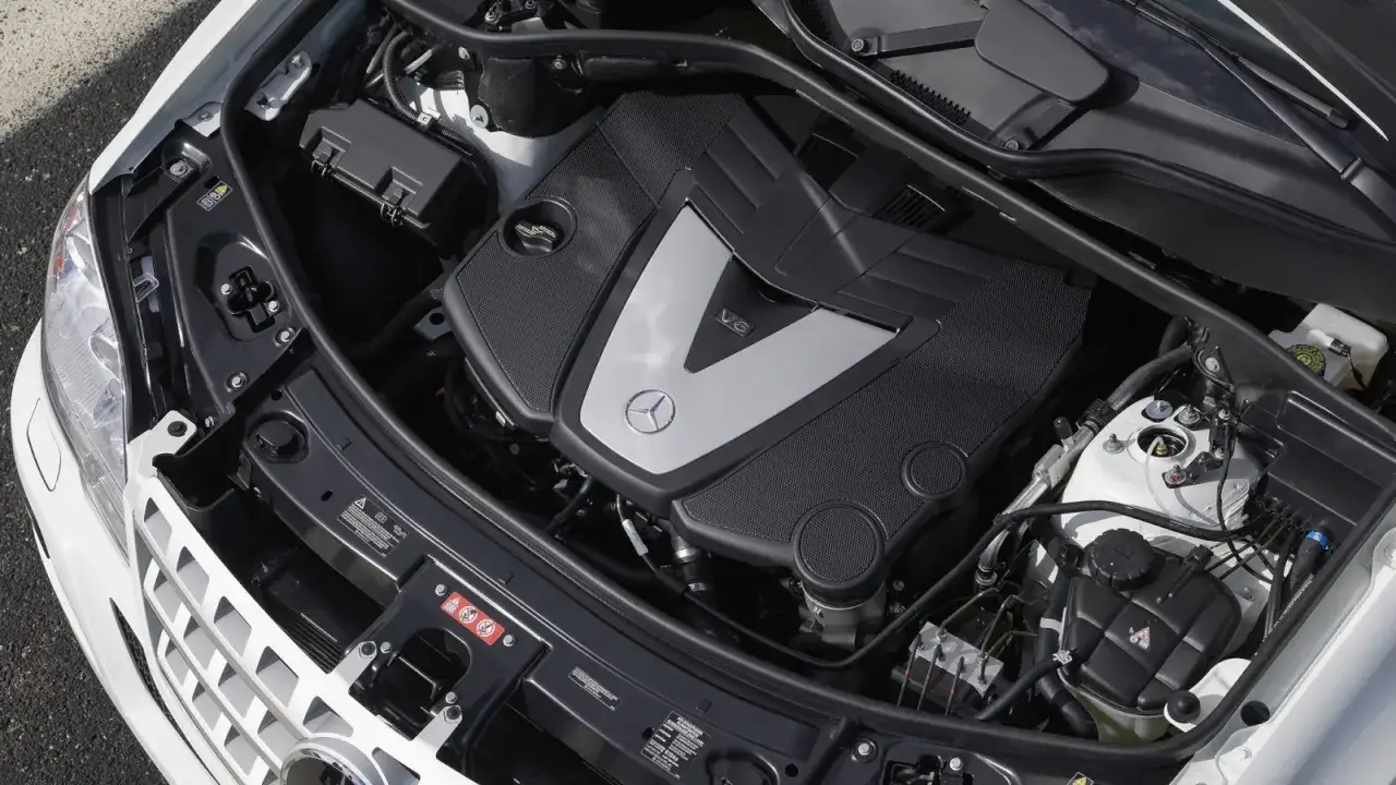 Silnik V6 om642 w Mercedesie, z widocznym logo marki i oznaczeniem V6.