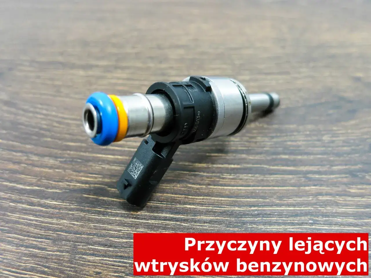 Wtryskiwacz benzynowy z niebieską i żółtą uszczelką. Przyczyny lejących wtryskiwaczy benzynowych mogą prowadzić do problemów z silnikiem.
