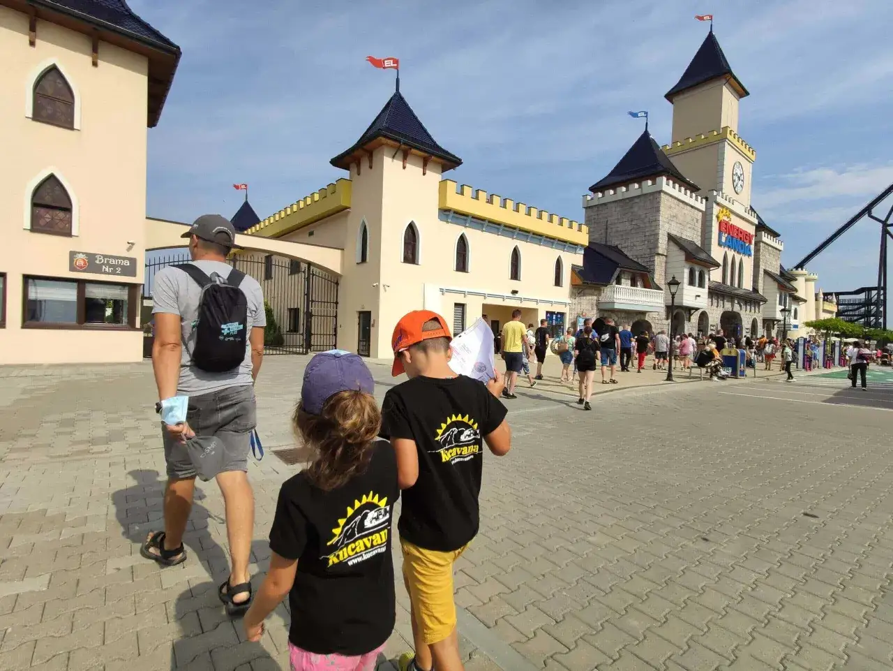 Familia disfrutando de un día en Energylandia, Polonia, con niños emocionados.