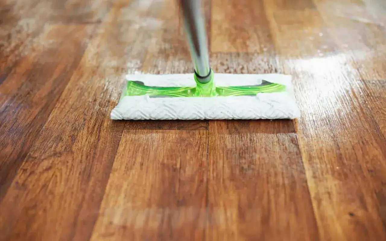 Mopa limpiando un suelo de vinilo con aspecto de madera, mostrando cómo quitar rayas y dejarlo reluciente.