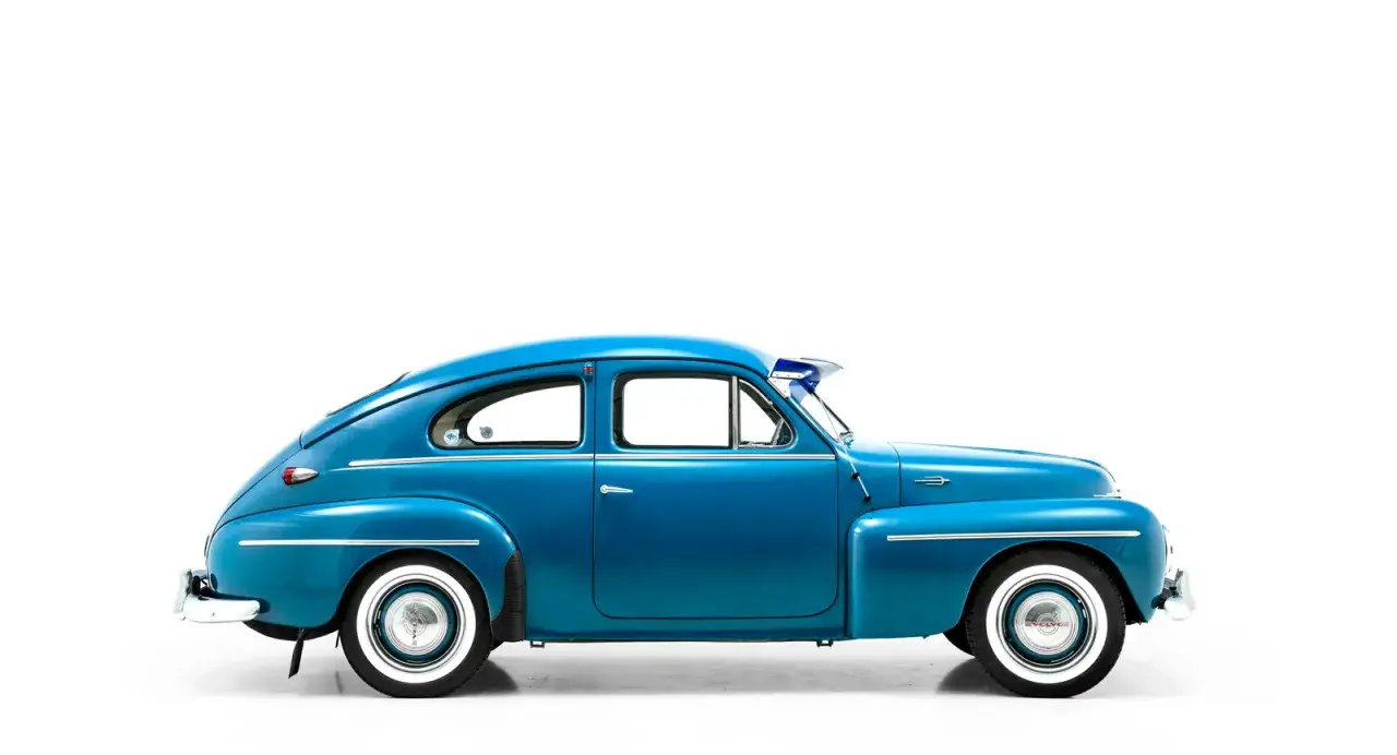 En blå Volvo PV 444, en klassisk svensk bil, står redo för en tur.