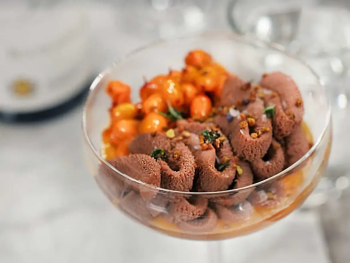 En lyxig choklad havtorn dessert i ett glas, med krämig chokladmousse och syrliga havtorn.