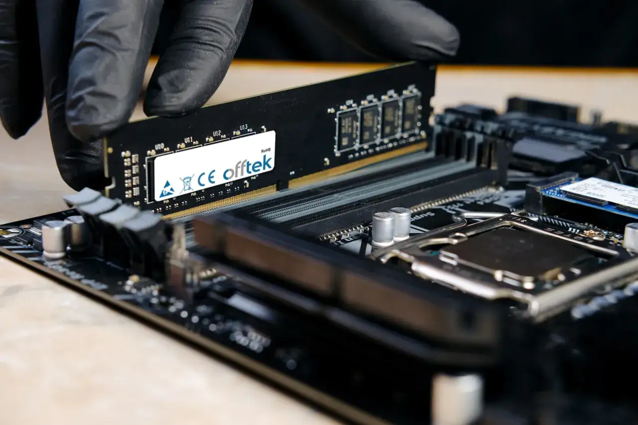 Installation d'une barrette RAM sur une carte mère. La RAM sert à stocker temporairement les données pour un accès rapide par le processeur.